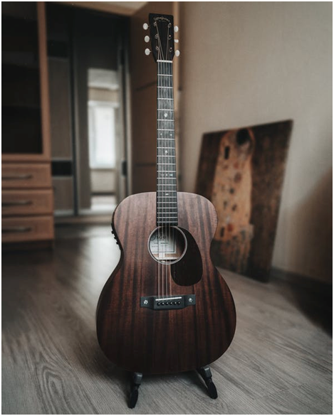 Acoustic guitar placed on a stand 